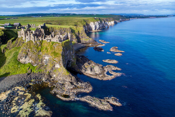 Ruins of medieval Dunluce Castle, cliffs, bays and peninsulas. Northern coast of County Antrim, Northern Ireland, UK.  Aerial view.
