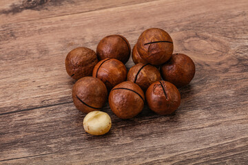 Brown macadamia nut heap over background