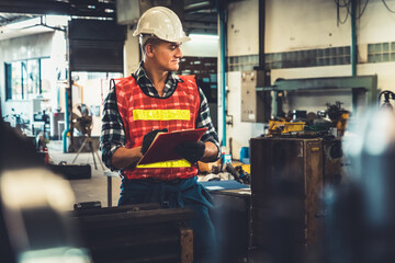 Manufacturing worker working with clipboard to do job procedure checklist . Factory production line occupation quality control concept .