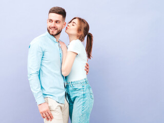 Smiling beautiful woman and her handsome boyfriend. Happy cheerful family having tender moments near purple wall in studio.Pure cheerful models hugging.Embracing each other