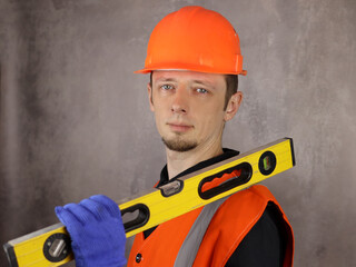 Portrait of a male engineer or builder with a construction level in hand