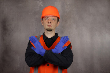 uniformed worker makes a stop gesture. No entry allowed