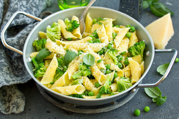 penne pasta with spinach pesto sauce, green peas and broccoli, top view