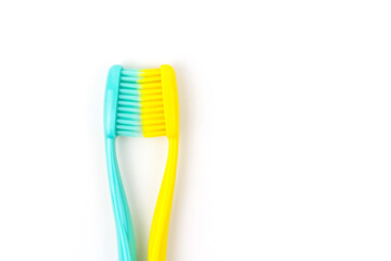 Blue and yellow toothbrushes on a white isolated background.