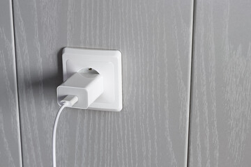 Charger power supply is connected to electrical outlet on wall