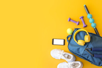 Set of sport equipment with backpack and mobile phone on color background