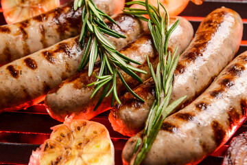 Delicious sausages cooking on grill, closeup