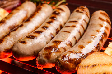 Delicious sausages cooking on grill