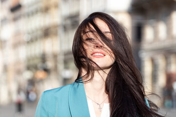 Portrait of a young woman in the city. Beautiful sensual brunette smiling.