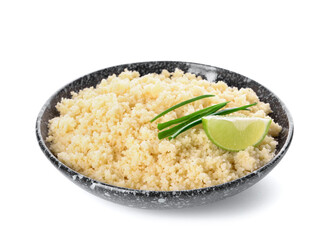 Bowl with tasty couscous, green onion and lime on white background