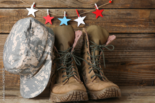 Military uniform and stars in colors of USA flag on wooden background