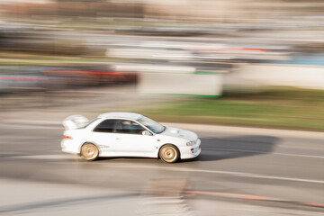 Fototapeta premium A racing car going fast on a road at sunset