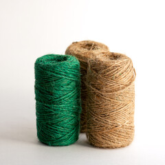 3 skeins of green and light dense threads on a white background vertical