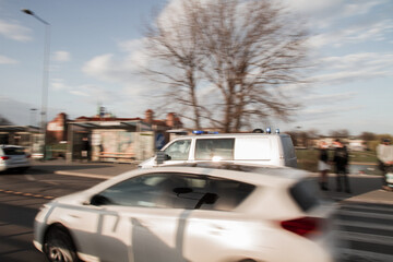 Fototapeta na wymiar A polish police van responding near intersection at sunset
