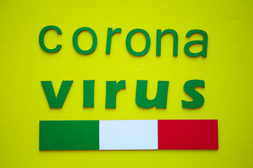 Italian Flag And Word CORONAVIRUS made of green cardboard letters, isolated on yellow background. World Health Organization WHO introduced new official name for Coronavirus disease named COVID-19