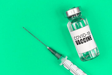 Vaccination against COVID-19 coronavirus background with vaccine vial and syringe