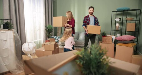 Happy Caucasian family couple moving home into new apartment with adorable little girl daughter discussing redecoration of furniture unpacking boxes and getting settled. Home comfort. Relocating day - Powered by Adobe