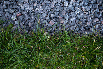 Gray small pebbles and green grass. Landscape design