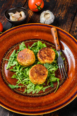 Fototapeta na wymiar Roasted chickpeas falafel patties with arugula on a plate. Dark wooden background. Top view