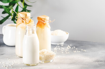 Fototapeta na wymiar Rice milk bottles on gray background. Non dairy alternative drink. Healthy vegan beverage