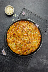 Almond homemade cake with sliced almonds topping crust on dark background. Top view. 