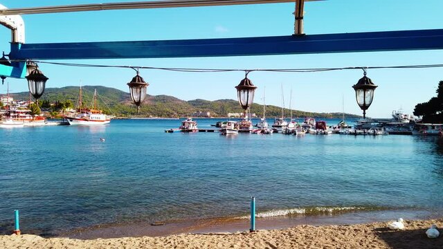 Suspended street lights, moored sailboats and view of the town on the background, Neos Marmaras, Greece. Slow motion