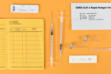 Concept for lift of restrictions for people with corona virus vaccination or negative test with certificate of vaccination, travel passport, syringe, vials and test result
