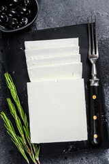 Greek cheese feta with rosemary and olives. Black background. Top view