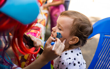a little girl gets aquagrim in the form of a dolphin