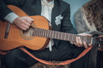 Fototapeta na wymiar man in an elegant suit plays the guitar