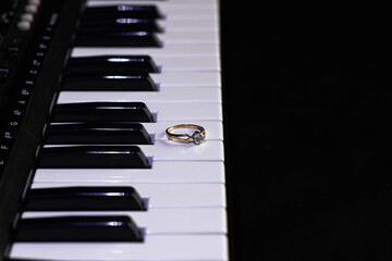 Engagement ring on a piano with dark background