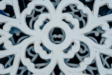 Metal flower pattern in a white chair.