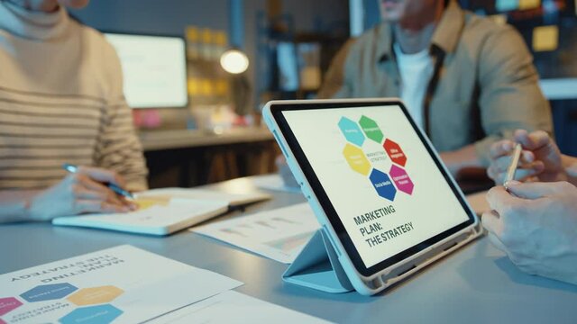 Close-up asia business people meeting plan analysis statistics brainstorm and header of team hold tablet pointing graph chart and employee take note. Finance strategy statistics success concept.