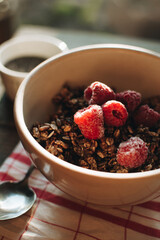 Delicious and healthy breakfast with raspberries. Morning aesthetics and beautiful layout on a wooden table. Granola for healthy breakfast.
