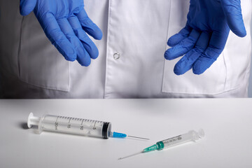 Doctor offers two syringes. Choice between small and big syringe. Syringes for vaccine inoculations...