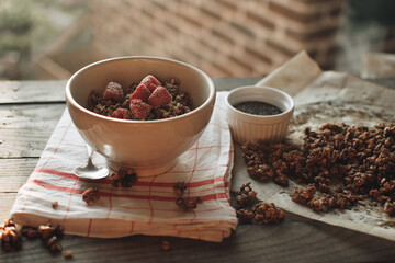 Delicious and healthy breakfast with raspberries. Morning aesthetics and beautiful layout on a wooden table. Granola for healthy breakfast.