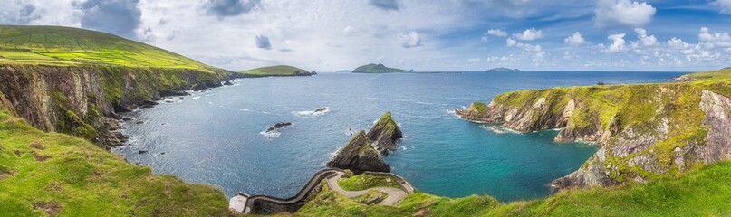 Beautiful panoramic shot of amazing Dunquin Pier and harbour with tall cliffs, turquoise water and...