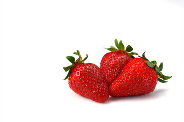 Three strawberries with leaves isolated on a white background.