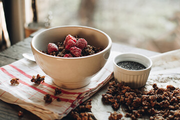 Delicious and healthy breakfast with raspberries. Morning aesthetics and beautiful layout on a wooden table. Granola for healthy breakfast.
