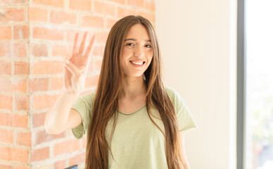 pretty woman smiling and looking friendly, showing number three or third with hand forward,...