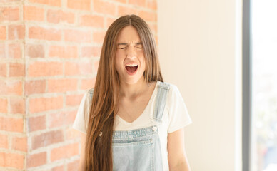 pretty woman shouting aggressively, looking very angry, frustrated, outraged or annoyed, screaming...