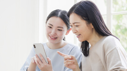 一緒にスマホを見る二人の女性