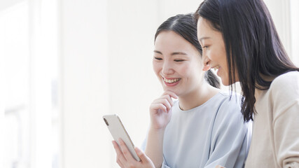一緒にスマホを見る二人の女性