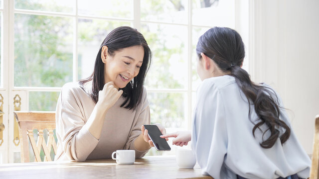 一緒にスマホを見る二人の女性