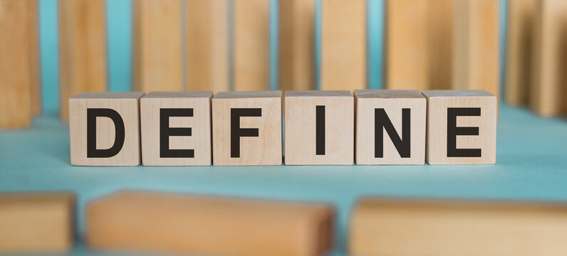 DEFINE word written on wooden blocks on light blue background.