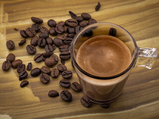 transparent coffee cup and coffee beans on brown wood background