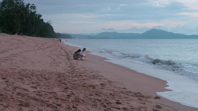 Happy young Chinese couple dating on beach,4K