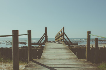 Fototapeta premium Wooden bridge to the beach at the Northern Litoral Natural Park in Esposende, Portugal. Scenic colorful sunset at the sea coast.
