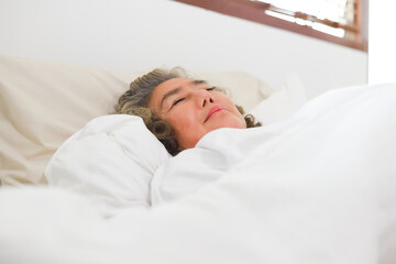 Fototapeta na wymiar Asian Elderly woman sleep and sweet dream on bed.