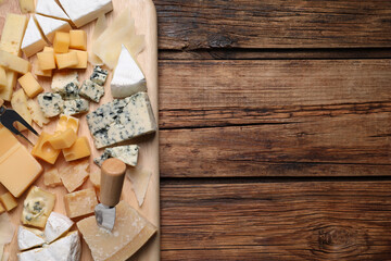 Cheese plate on wooden table, top view. Space for text